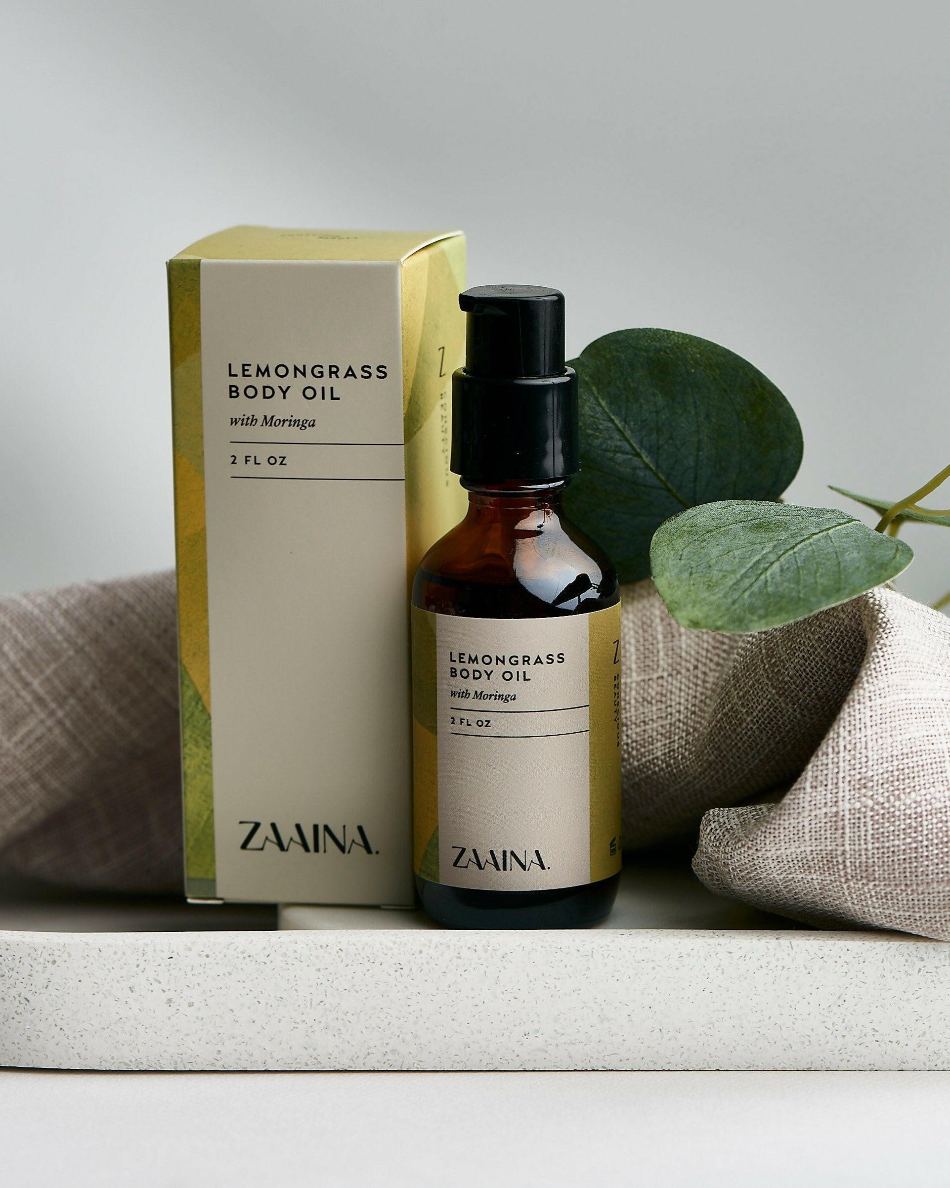Lemongrass body oil in a glass bottle displayed on a wooden table for natural skincare routines