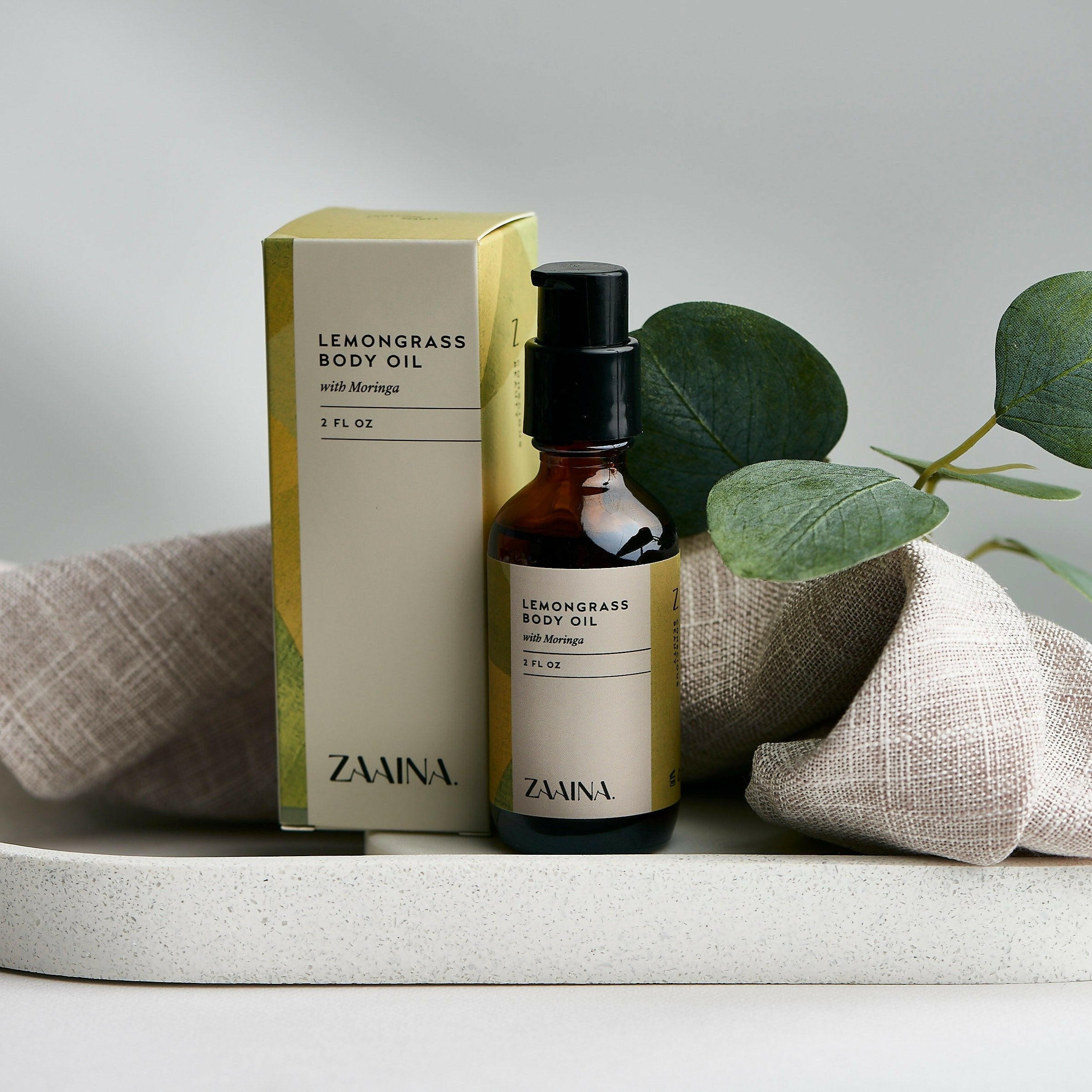 Lemongrass body oil in a glass bottle displayed on a wooden table for natural skincare routines